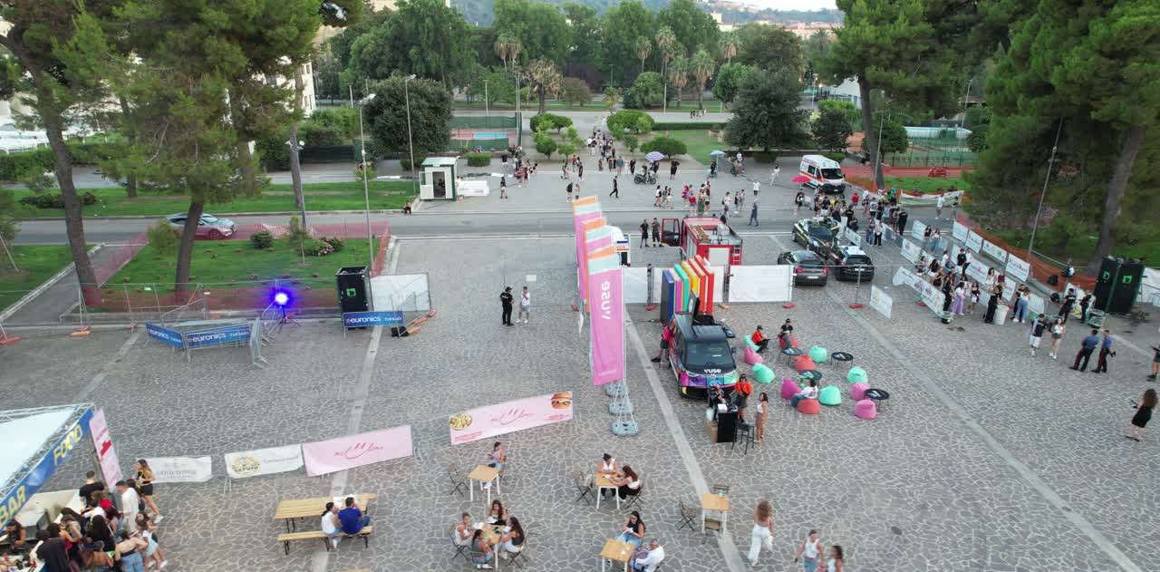 Il piazzale dell'Arena Flegrea durante un evento, con bandiere e area lounge